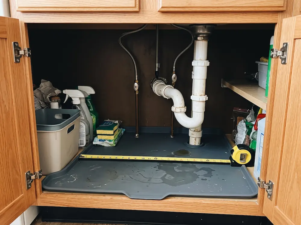 Measuring available space around drain pipes and shut-off valves under a kitchen sink