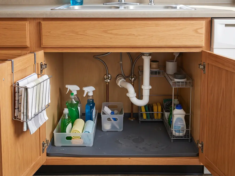 Removable bins and a compact two-tier organizer arranged around under-sink plumbing